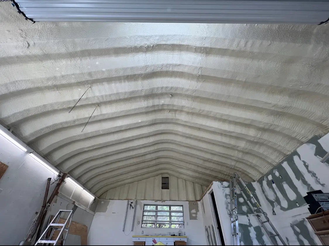 Spray polyurethane foam applied to the underside of a metal roof deck in Harris